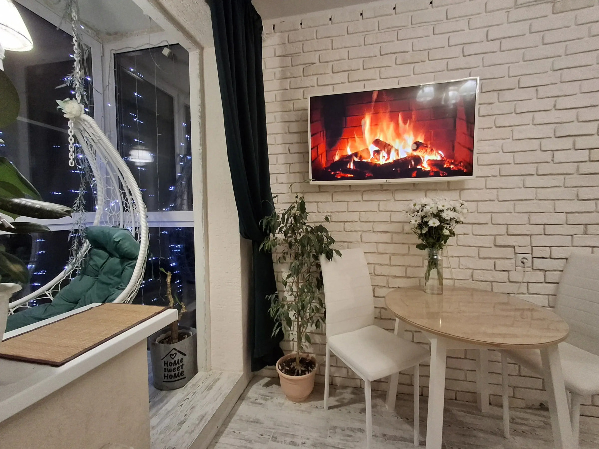 Квартира с подвесными креслами из ротанга на панорамной лоджии